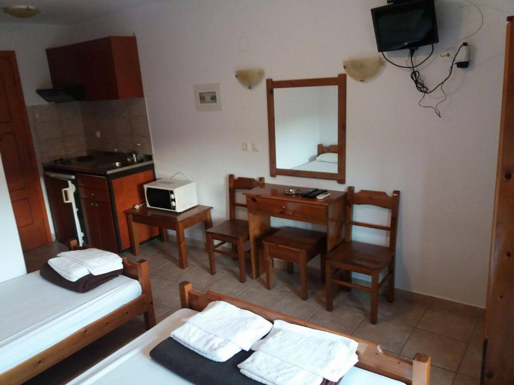 a bedroom with a bed and a desk and a mirror at Hotel Kosmas in Sarti