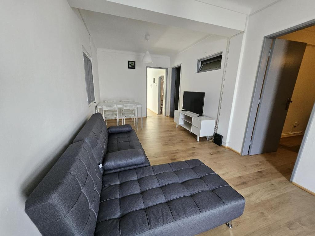 a living room with a couch and a television at T2 Res Chao Jardim in Vila Nova de Milfontes