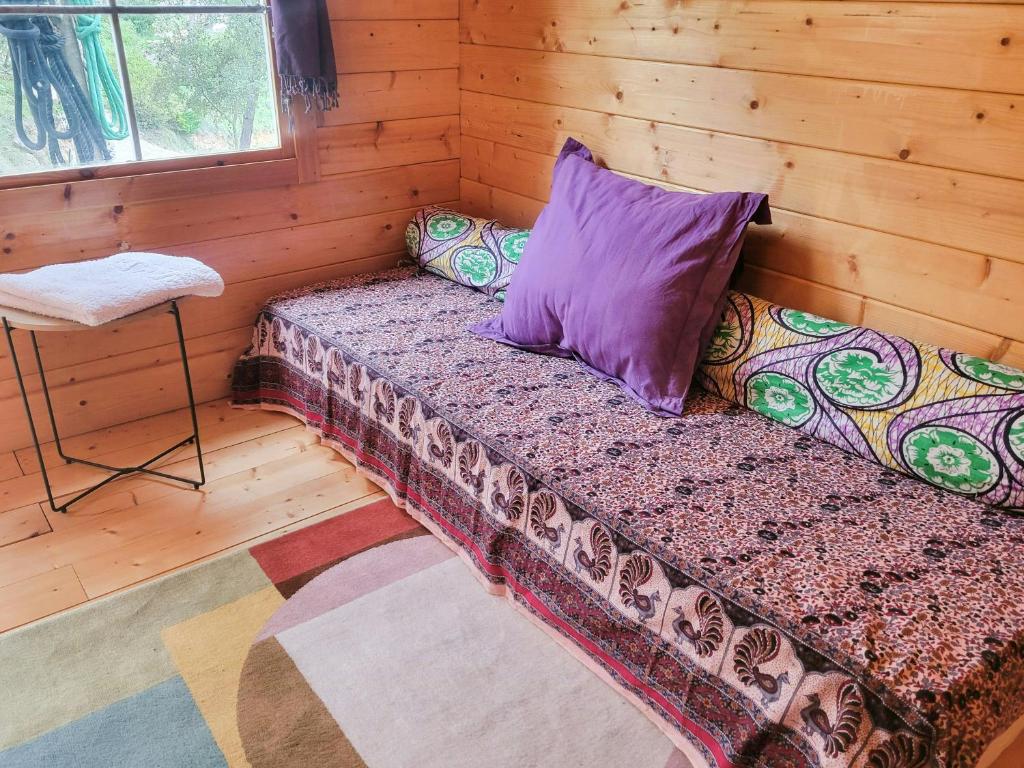 a bed in a log cabin with a pillow and a chair at Peaceful Villa Between Saint-Tropez And Verdon in Vidauban