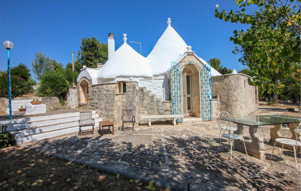 Una iglesia con una mesa y bancos delante de ella. en Gorgeous Home In Ostuni With Wifi, en Ostuni
