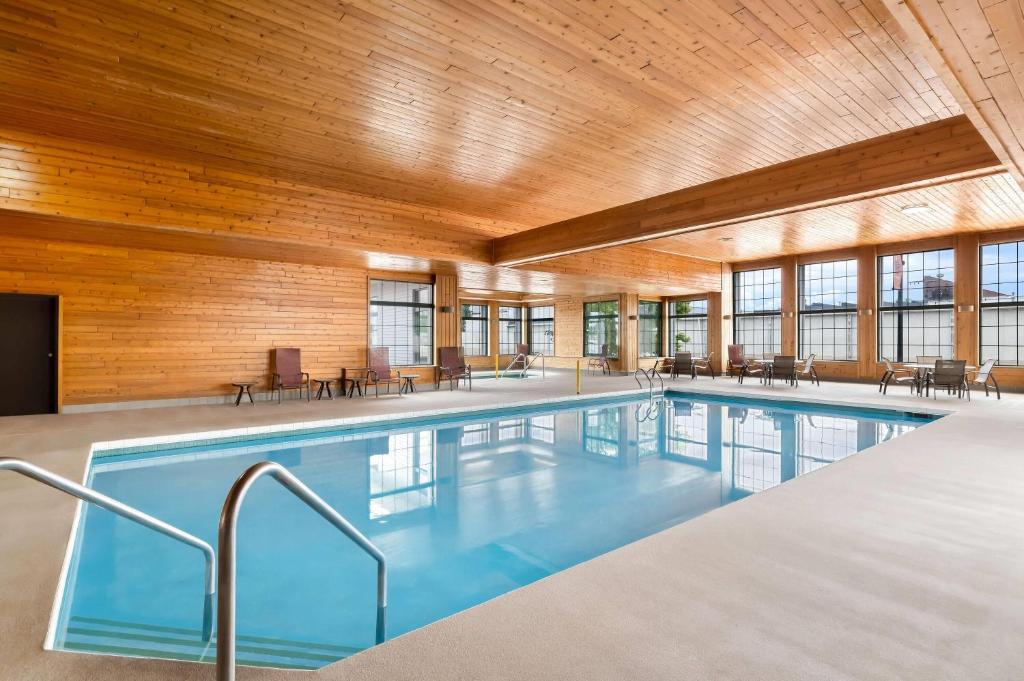 a swimming pool in a building with a wooden ceiling at Super 8 by Wyndham La Crosse in La Crosse