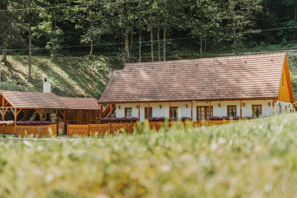 a white building with a brown roof at LOLO Park Resort in Lacu Rosu