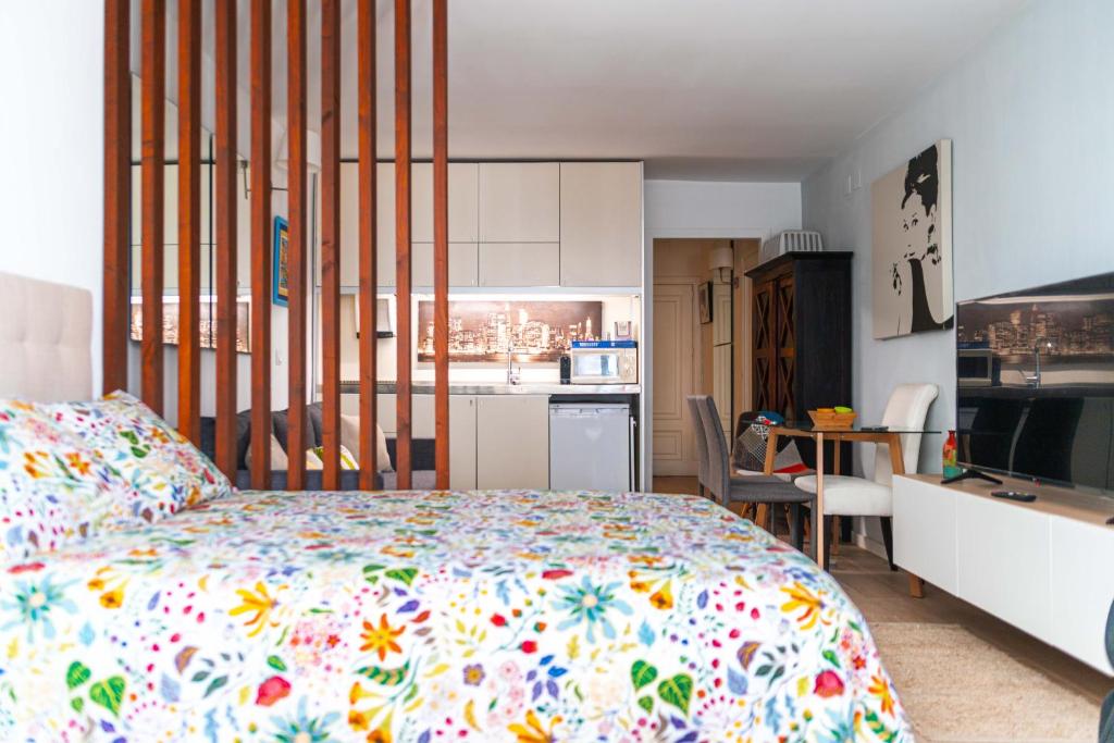 Hotel Cozy Suite next to Plaza del Ayuntamiento, a bedroom with a bed with a floral bedspread at Cozy Suite next to Plaza del Ayuntamiento in Valencia