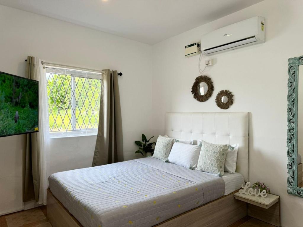 a bedroom with a white bed and a window at Sun-kissed Holidays Goa-Sapphire in Siolim