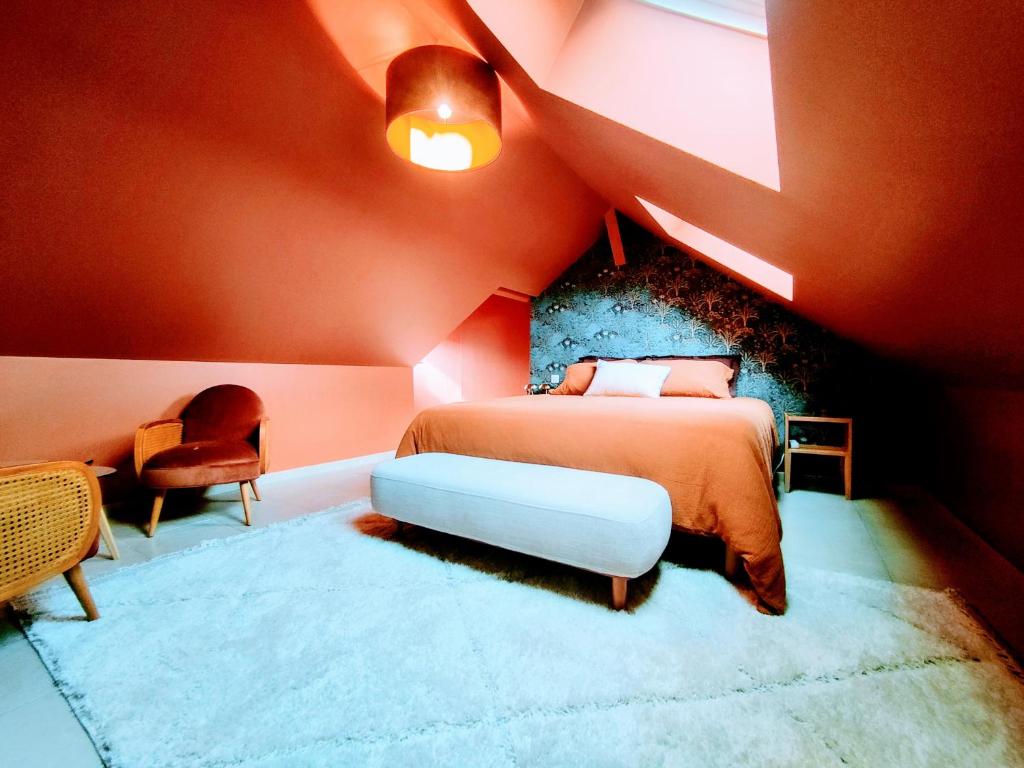 - une chambre rouge avec un lit et une chaise dans l'établissement Faillot - Séjour à Auxerre, à Auxerre