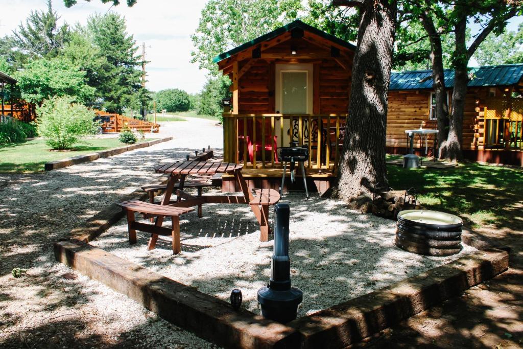 Una cabaña de troncos con mesas de picnic y un árbol. en #3 - Amish Built Log Cabin Fishing Hunting Camping cabin, en Toronto
