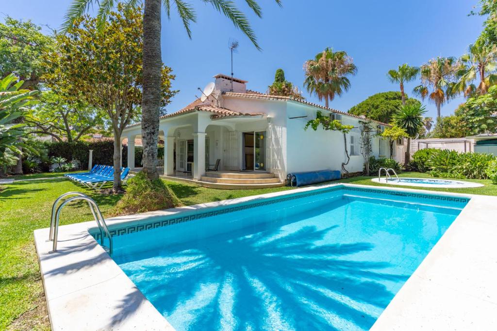 a swimming pool in front of a house at Beautiful Villa La Caracola in Marbella