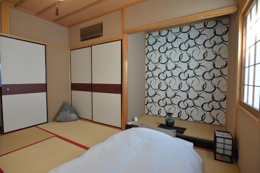 a bedroom with a bed and a large window at JR京都駅徒歩10分。お風呂が素敵な貸切一軒家。４人まで最適。 in Kyoto
