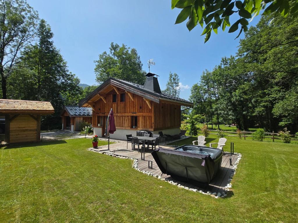a log cabin with a table and a boat in the yard at Chalet Pierre d Anatase in Saint-Gervais-les-Bains