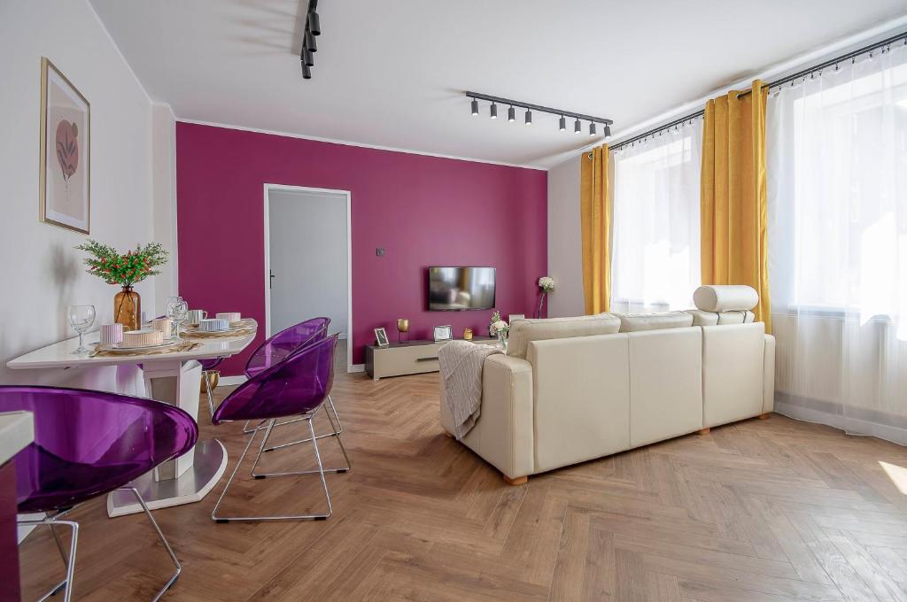 a living room with a white couch and purple chairs at Bytom Merlot in Bytom