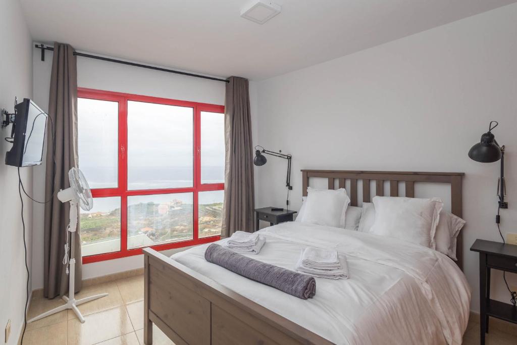 Un dormitorio con una cama grande con una ventana grande. en 2BR BuenaVida Residential, en Breña Baja