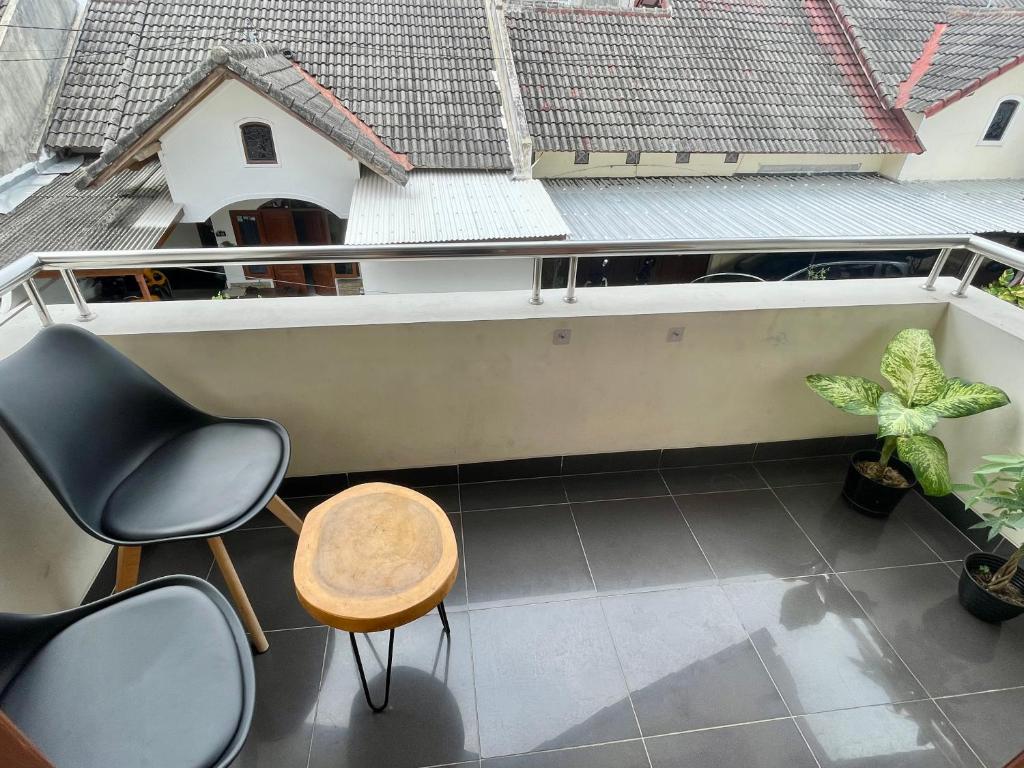 a balcony with chairs and a table at Ndalem Suryo Guesthouse in Yogyakarta