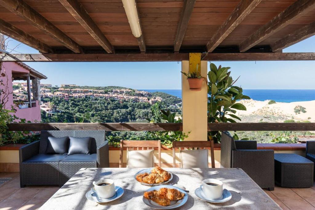 a table with two plates of food on a balcony at Costa Verde - Panoramic Stay Terrace Wifi BBQ AC in Torre Dei Corsari