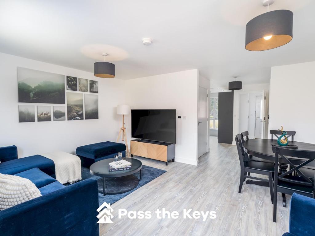 a living room with a blue couch and a table at Pass the Keys Modern Townhouse with Garden and Parking in Ascot in Ascot