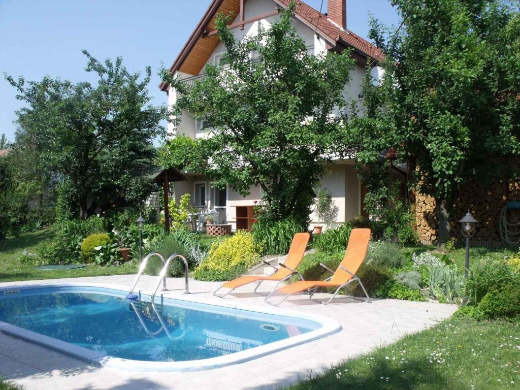una piscina con due sedie e una casa di Apartments in Fonyod - Balaton 18584 a Fonyód