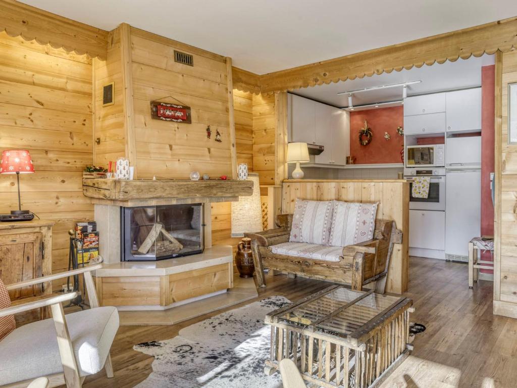Elle comprend un salon doté d'une cheminée et de murs en bois. dans l'établissement Appartement à Megève, 3 chambres, proche centre, piscine, tennis, cheminée, parking, classé 3 étoiles - FR-1-453-139, à Megève