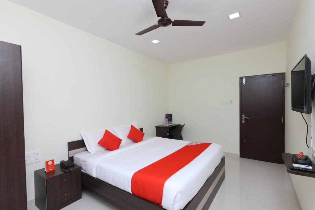 a bedroom with a bed and a flat screen tv at Super Hotel O Perfect Stay Near Meenambakkam Metro Station in Chennai