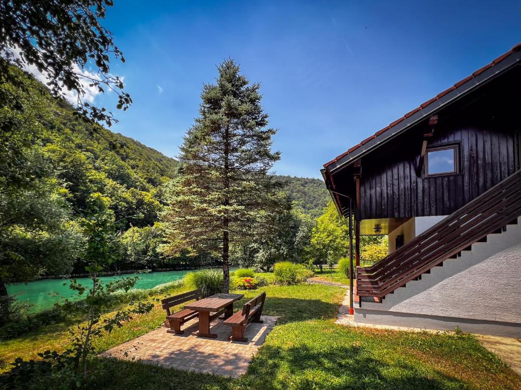 a picnic bench next to a building next to a river at Casa Kolpa in Dragatuš