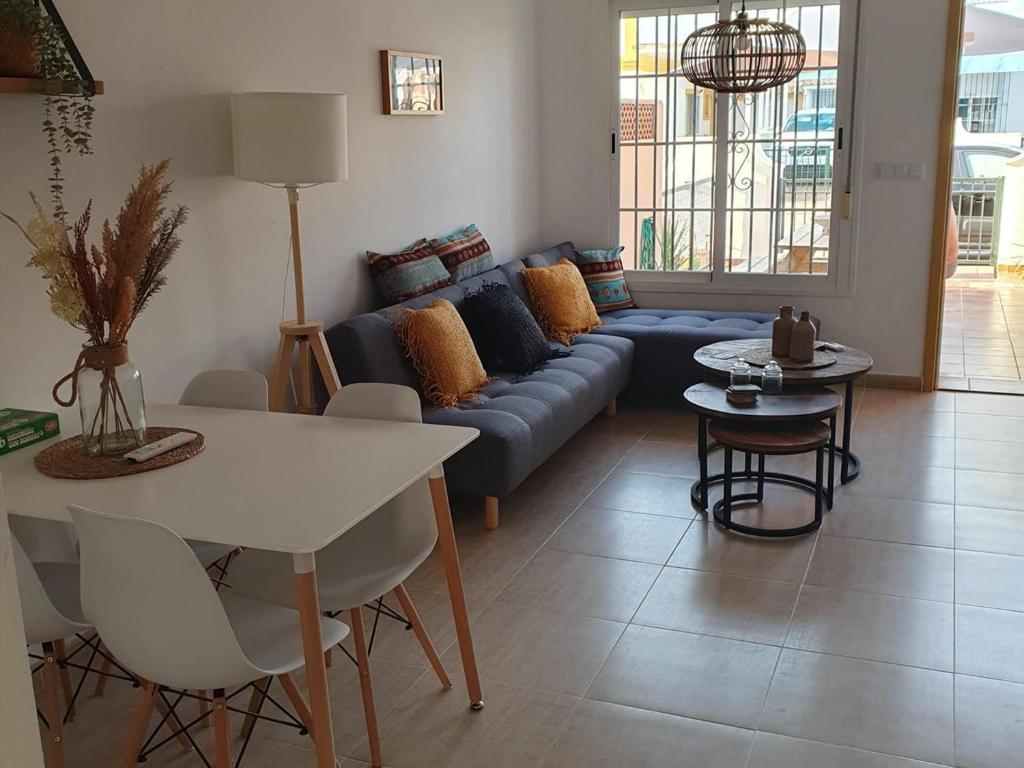 ein Wohnzimmer mit einem blauen Sofa und einem Tisch in der Unterkunft Casa acogedora cerca de la playa en San Juan de los Terreros - ES-376-9 in Pulpí