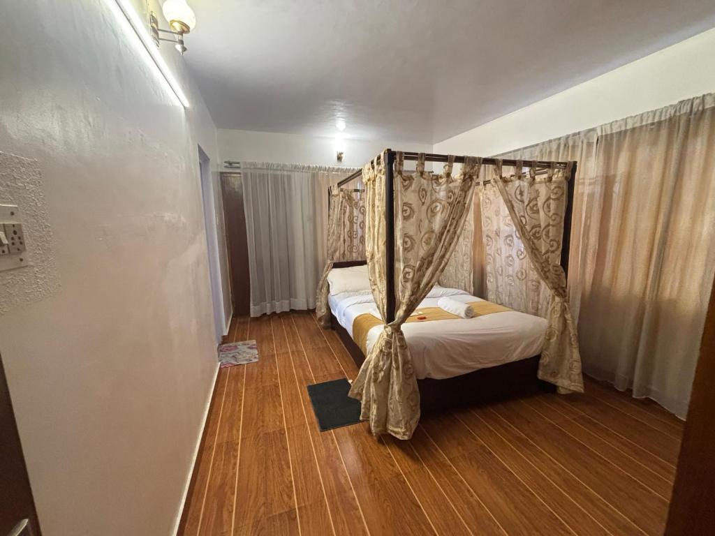 una camera da letto con un letto a baldacchino di PSR Rooms and Cottages a Ooty
