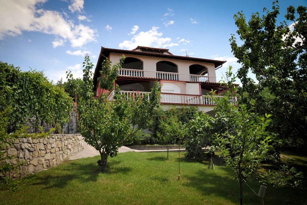 a house with a yard with trees in front of it at Apartments in Lopar - Insel Rab 36282 in Lopar