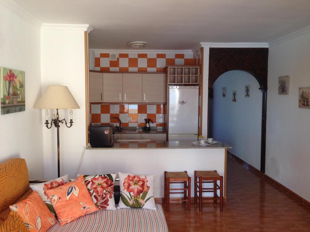 a living room with a couch and a kitchen at Apartamento Muelle de Corralejo 14 in Corralejo