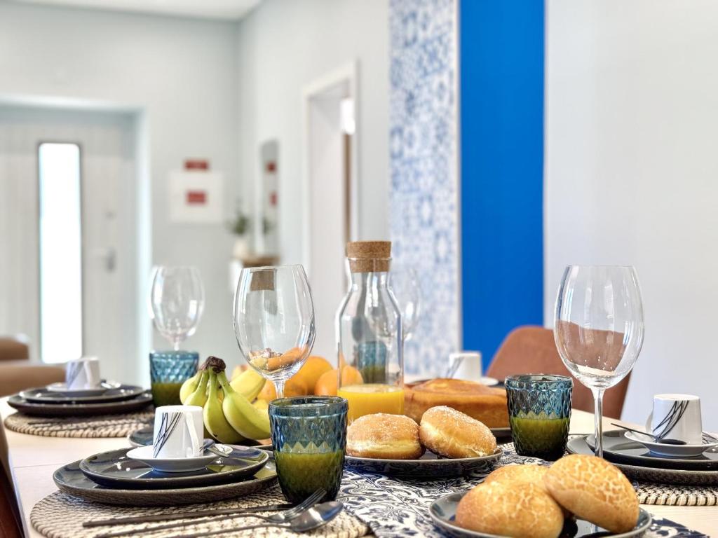 a table with wine glasses and food on it at Almancil Typical House by Homing in Almancil