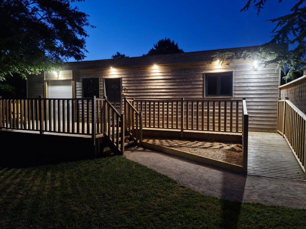 une maison avec une clôture en bois la nuit dans l'établissement La Cabane du bois l'abbé, à Saint-Martin-Boulogne