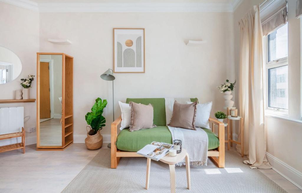 a living room with a green couch and a table at BnBNova - 1BR - Holborn & Central London - The Museum in London