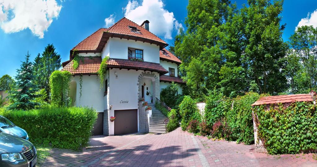 a white house with a red roof at VILLA CASSIA w Rabce przy Parku Zdrojowym - smaczne śniadania i obiady in Rabka-Zdrój