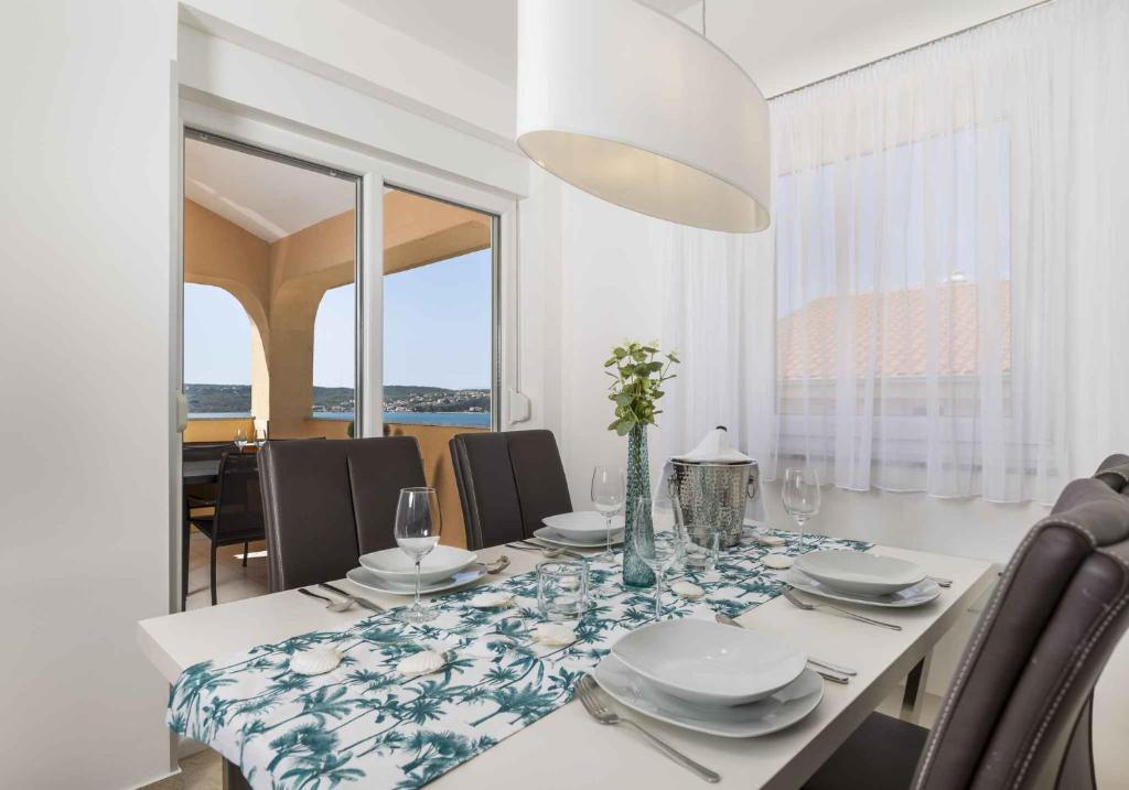Un comedor blanco con una mesa y sillas. en Apartment in Klimno - Insel Krk 49859, en Klimno
