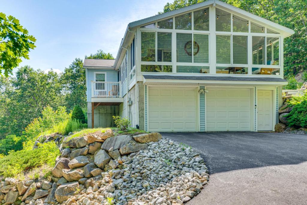 a house with a large window and a stone wall at 3 Mi to Gunstock Mountain Resort Gilford Getaway in Gilford