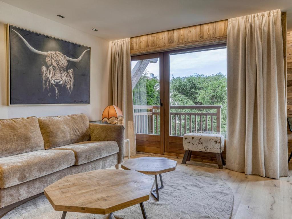 un salon avec un canapé et une grande fenêtre dans l'établissement Appartement cosy 2 pièces à Megève, proche pistes et golf, avec balcon et jardin, pour 4 personnes. - FR-1-453-83, à Megève