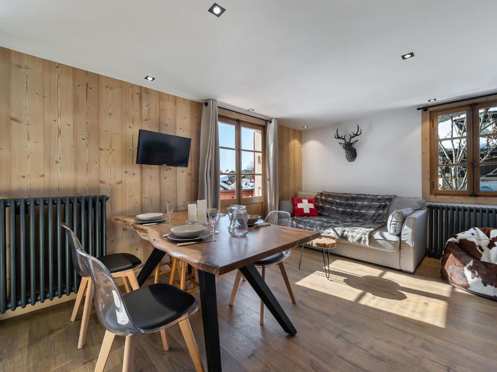 un salon avec une table, des chaises et un canapé dans l'établissement Appartement cosy 2 chambres, centre de Megève, balcon, wifi, parking - FR-1-453-176, à Megève