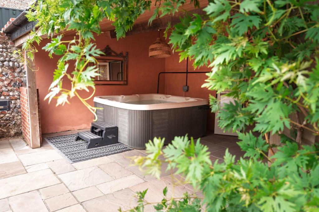 a hot tub sitting in the middle of a courtyard at Studio Sleeps 2 w HotTub-Garden-PetsOK-Parking in Cromer