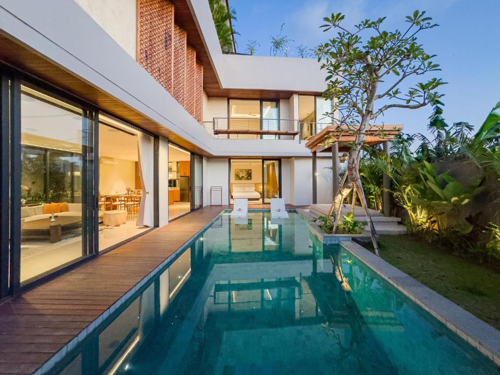 an external view of a house with a swimming pool at Narawangsa Villa 4br Amazing Sunset Rooftop in Kerobokan