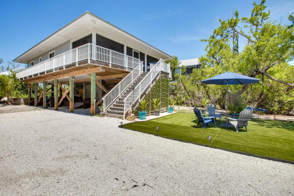 a house with a patio and a table and an umbrella at Little Gasparilla Island Escape on Private Island! in Placida