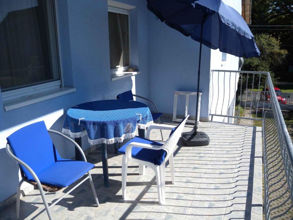 - une table, des chaises et un parasol sur la terrasse dans l'établissement Apartment Zalakaros 5, à Zalakaros