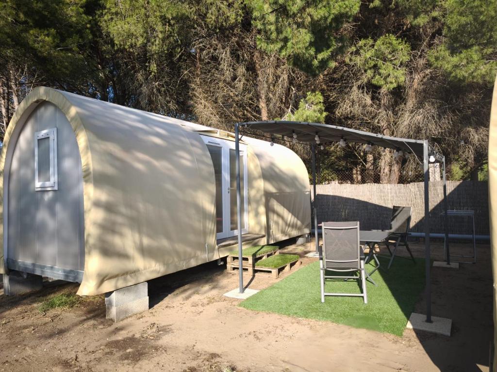 une remorque argentée avec une table et une chaise dans l'établissement Du coté de chez Swann à 150 m de la plage, à Vias