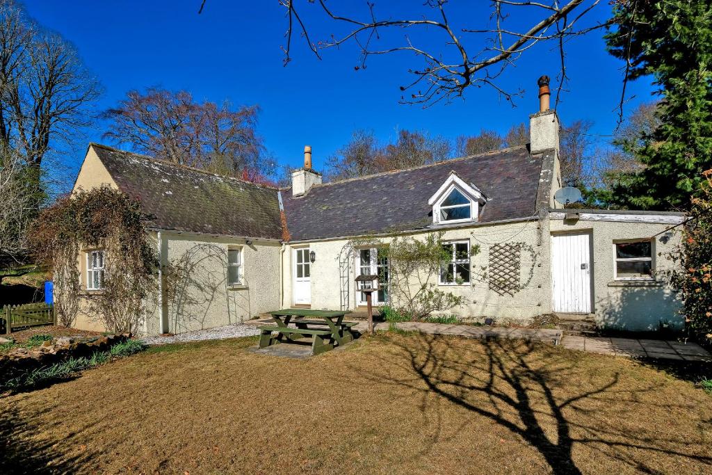 a house with a picnic table in front of it at Finest Retreats - Corrennie School Cottage in Inverurie