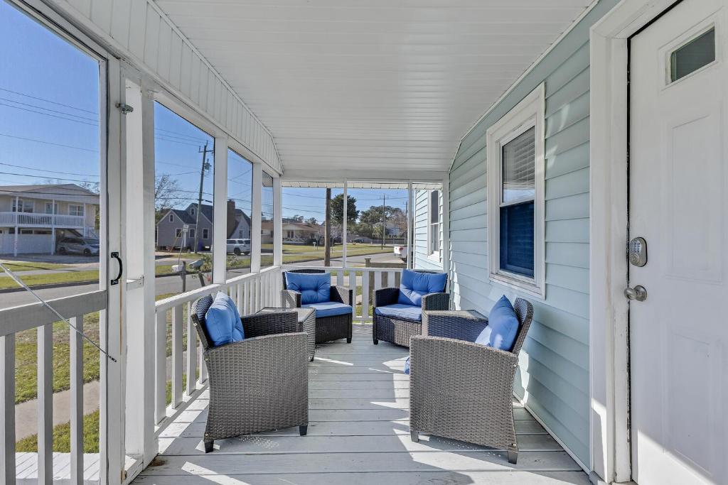 Rocky PointにあるHarper Estate by Carolina Beach Realtyの籐の椅子と青い枕が備わるポーチ