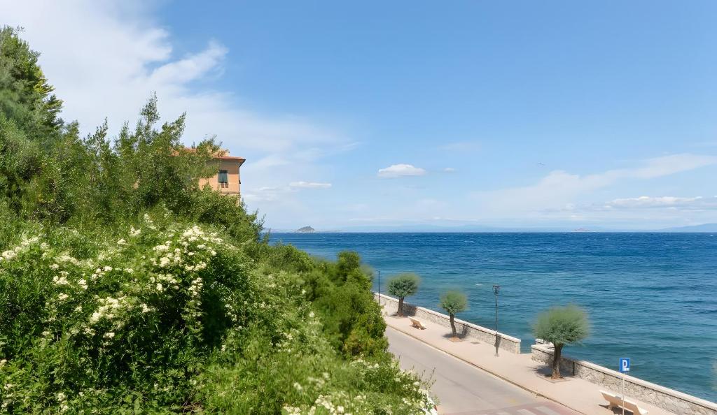 a road by the ocean with a building on a hill at Residenza Rio Marina de luxe in Rio Marina