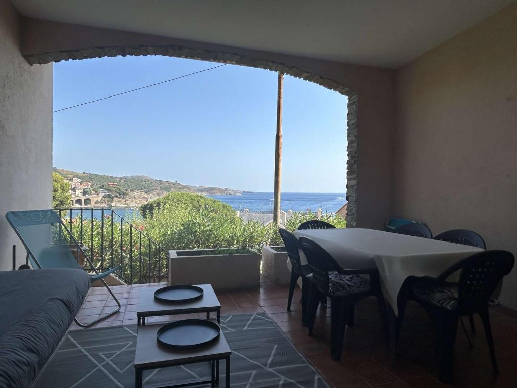 - un salon avec une table et une vue sur l'océan dans l'établissement Appartement 3 pièces avec jardinet proche centre Banyuls - FR-1-225C-39, à Banyuls-sur-Mer