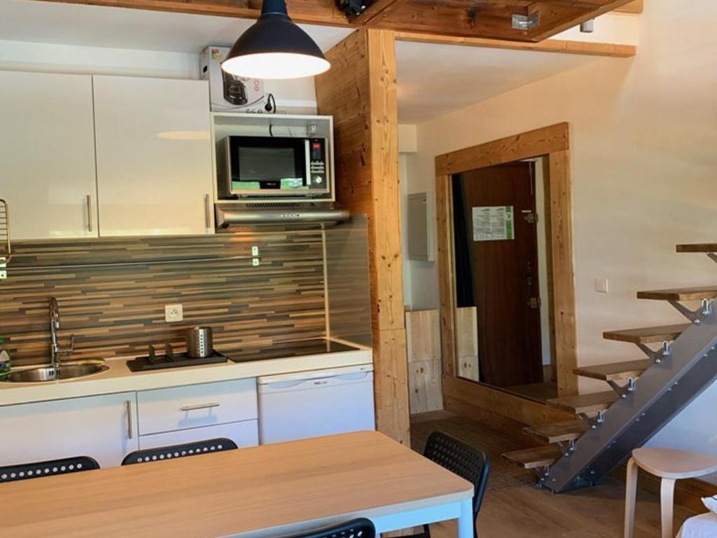 une cuisine avec un évier et un micro-ondes dans l'établissement Charmant 2 pièces pour 5 pers, au pied des pistes, 24m², Vieil Alpe, Alpe d'Huez - FR-1-405-217, à Huez