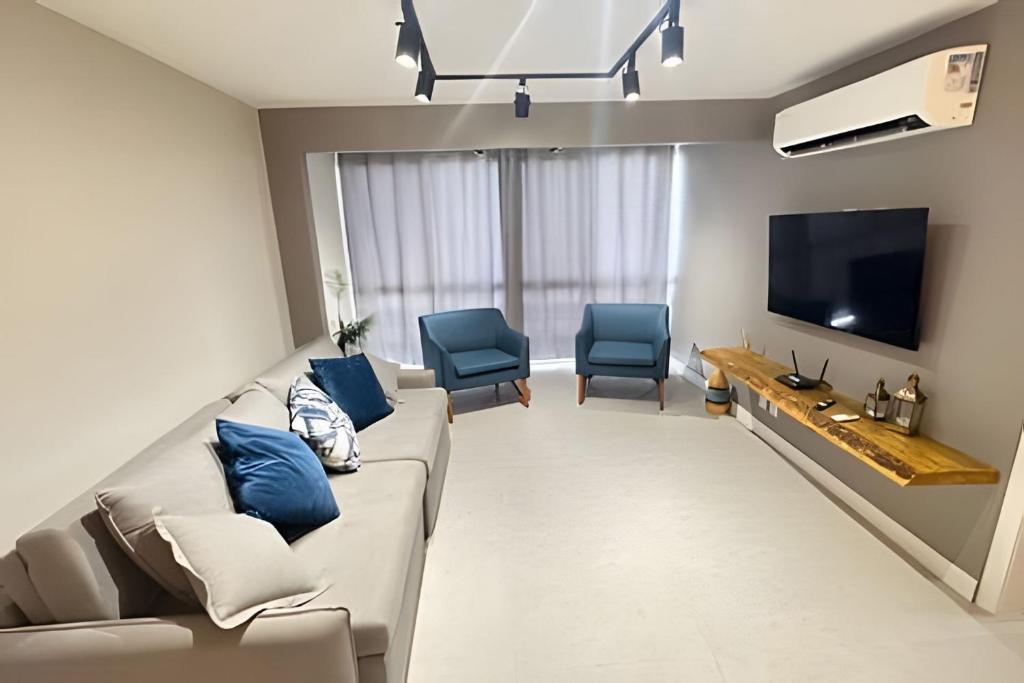 阿拉亚尔-杜卡布Todo reformado pertinho da praia的客厅配有沙发和2把蓝色椅子