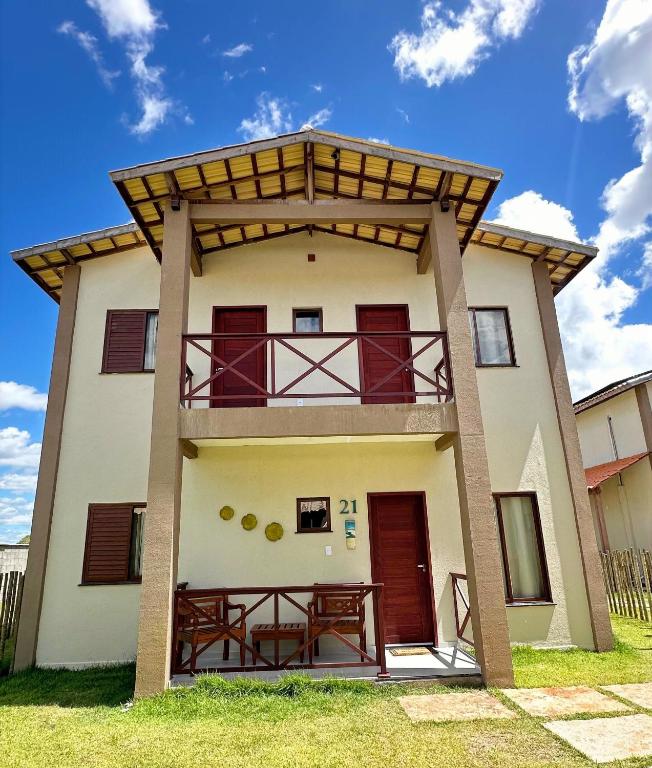 a house with a balcony on the side of it at Chalet Paraíso Lençóis Santo Amaro in Santo Amaro