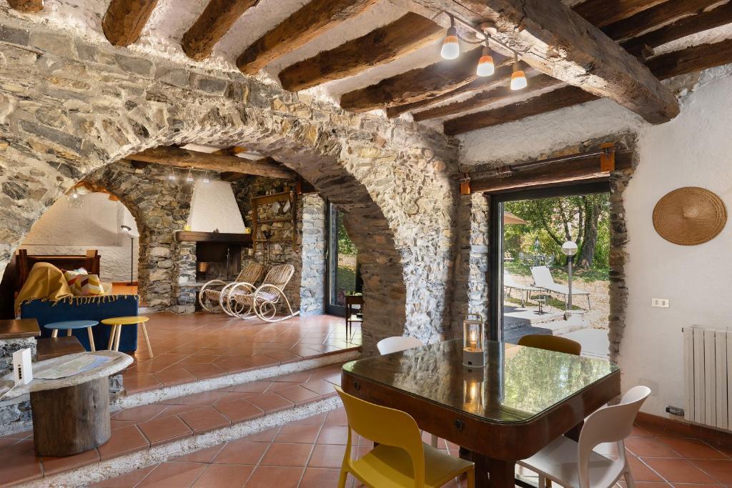 a living room with a table and a stone wall at Villa Franca Nature Holidays in Rezzo