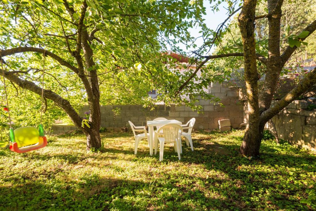 a table and chairs in a yard with trees at Appartamento Villanova in Villanova Strisaili