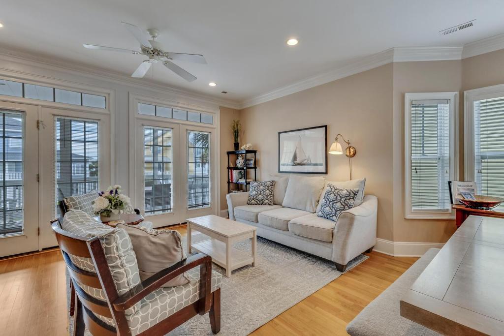 a living room with a couch and chairs and windows at The Pelican in Carolina Beach