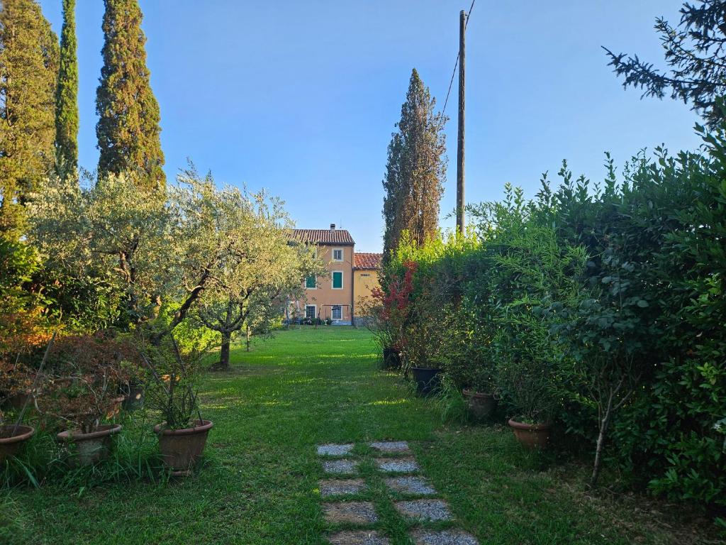a garden with trees and a building in the background at La Corte del Tadde in Lammari